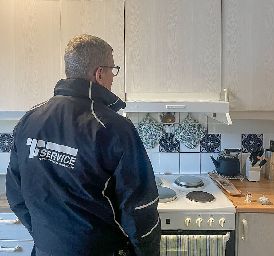 Personal från Teknisk Fastighetsservice framför spiskåpa