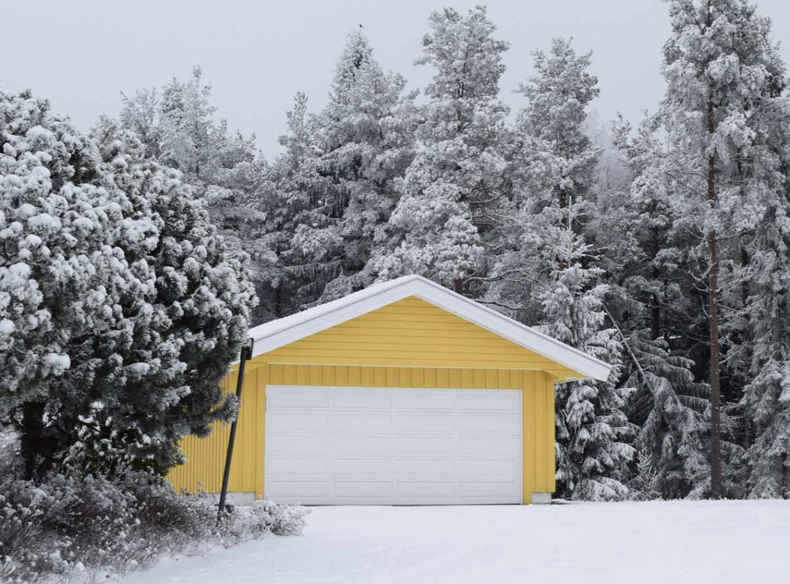 Ett gult garage i vinterlandskap